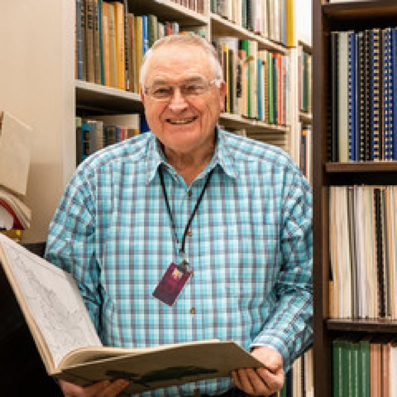A librarian smiling after helping a student find a book