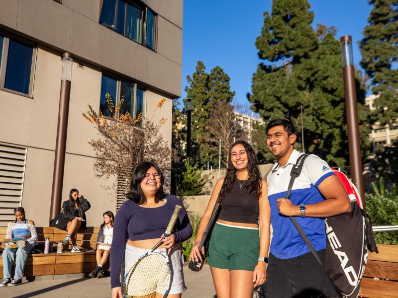 Students smiling with tennis rackets